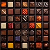 Close-up of assorted chocolates arranged in a grid box showing various chocolate types and decorative patterns