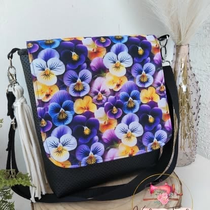 Colorful patterned crossbody bag with pansy flowers in purple, yellow, and white on black base